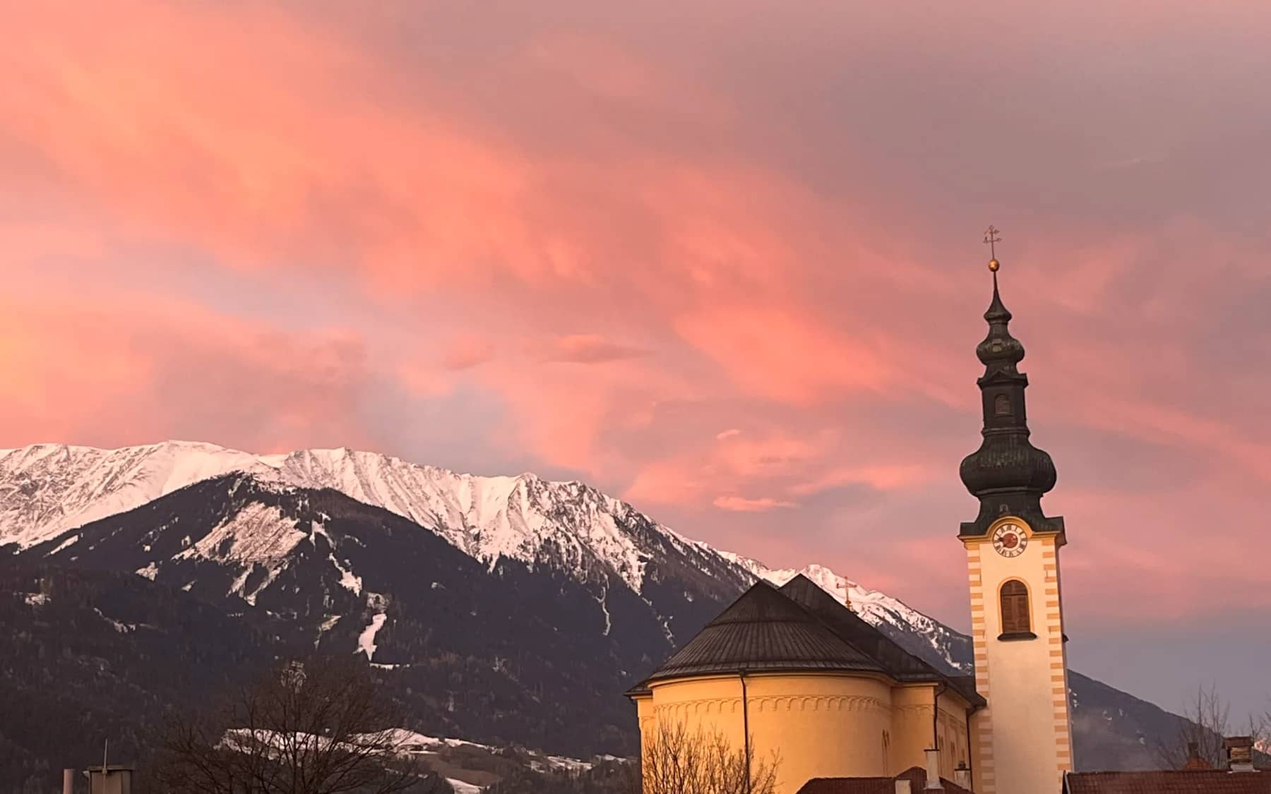 Pfarrkirche und Tiroler Berge im Abendlicht